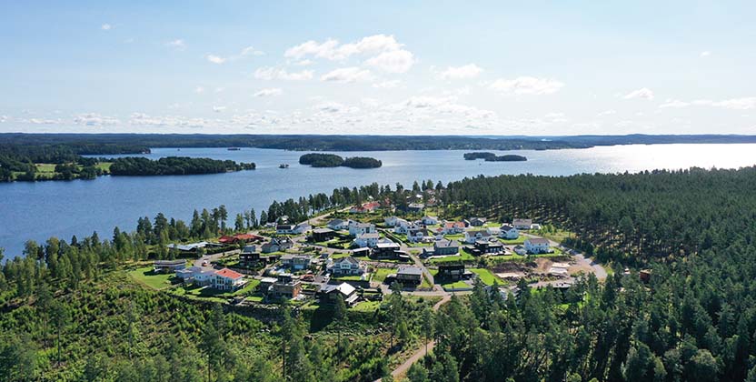 Flygbild över bostadsområdet Norraby med sjö som bakgrund.