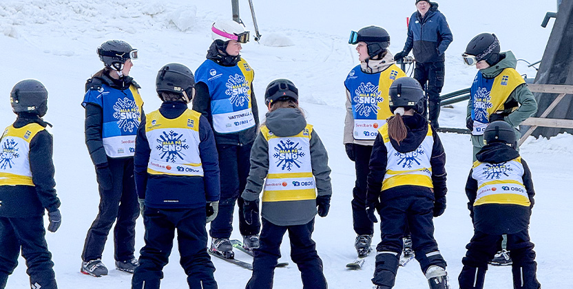 Skidlärare med elever i en skidbacke.