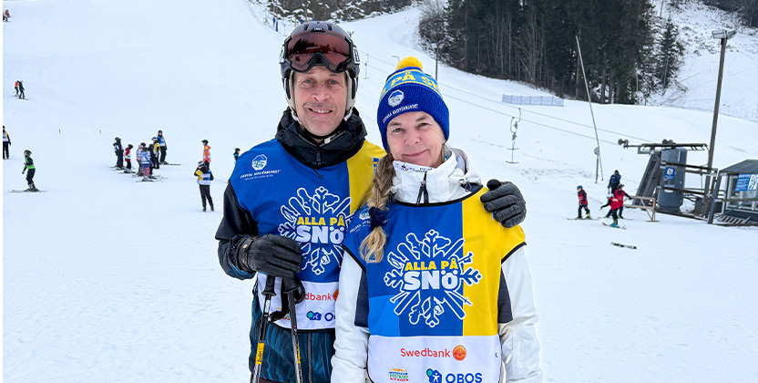 Två personer i en skidbacke.