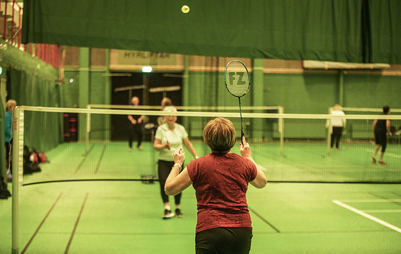 Två damer i badmintonduell. 