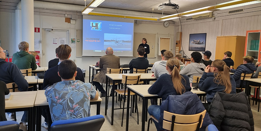 Person som föreläser framför en gymnasieklass.